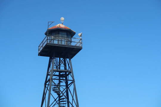 A landscape orientation of the guard or watch tower of the prison on the Island of Alcatraz, San Francisco. Isolated against a bright blue sky.