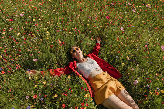 Happy woman lying on flowering plants in field