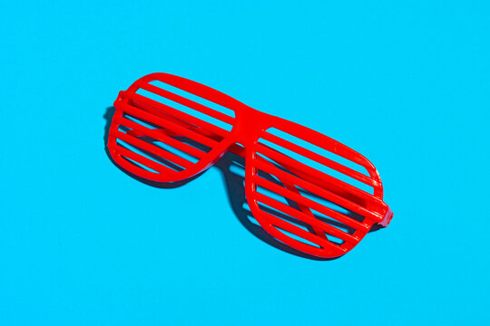 Red striped futuristic fashion glasses over blue background