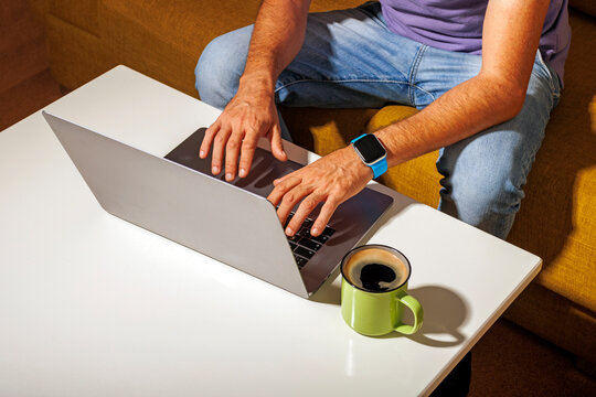 Freelancer working on laptop near coffee cup at table