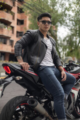 Biker on a sunny day, relaxed lifestyle, portrait of young latin person wearing a leather jacket,...