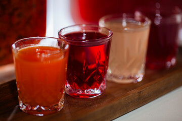 Colorful alcoholic shots standing on a wooden tray, ready to be served by bartender