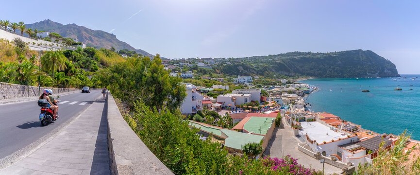 View of motorcyclist on road overlooking Spiaggia di Citara, Forio, Island of Ischia, Campania, Italy, Europe