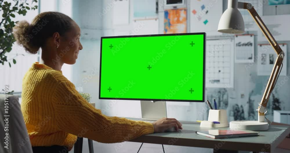 Poster black female engineer works at desktop computer with green chroma key screen in modern office, focus