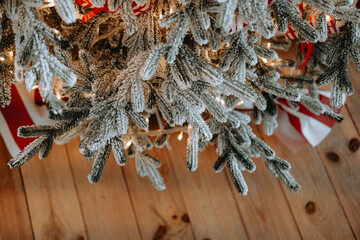 Naklejka premium Frosted Christmas tree branches adorned with twinkling lights and gifts