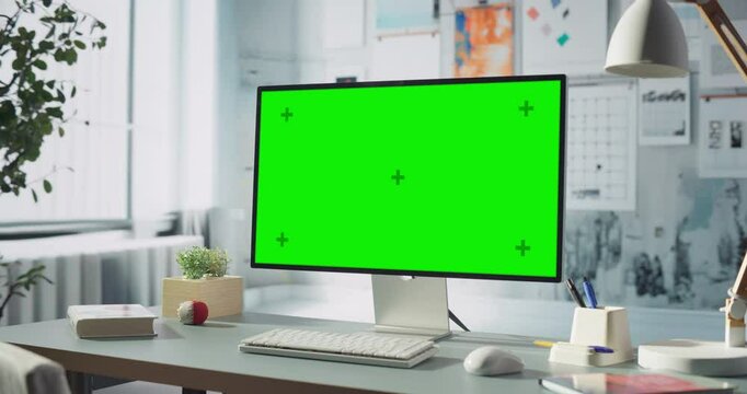 Desktop Computer With Green Chroma key Screen Is on Modern Office Desk, Engineering, Creative Projects, or Software Development Tasks, work, Home Office concept. Zoom out shot