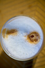 a glass of cappuccino with a blurred background.