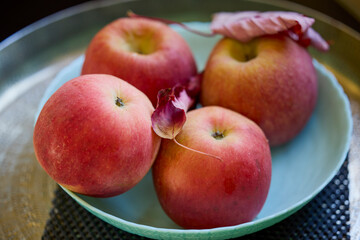 a plate of red apples on a table