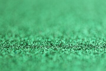 Beautiful green glitter sparks texture as background with shallow depth of field