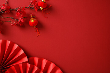 Lunar New Year 2025 concept. Flat lay Chinese red paper fans, cherry blossoms tree branch with...