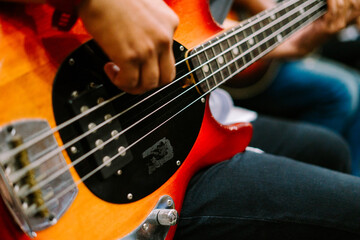 Obraz premium A musician passionately playing an electric bass guitar, showcasing skill and rhythm