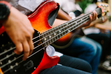 Fototapeta premium A musician passionately playing an electric bass guitar, showcasing skill and rhythm