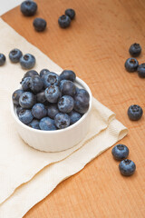Fresh blueberries in a bowl on a wooden table. Wild berries, Healthy eating