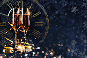 Merry Christmas and Happy New Year! Two glasses of champagne and a gold streamer on a dark blue background.