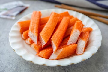 Crab stick in white plate  on grey background