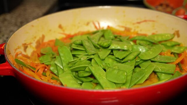 Adding of hyacinth beans on delicious veg cuisine by chef in kitchen.