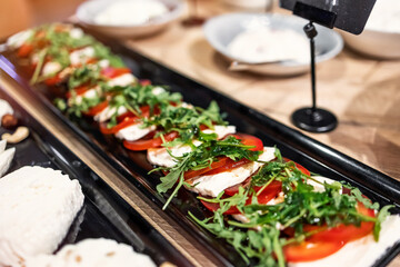 Fresh caprese salad with tomatoes and mozzarella on a platter