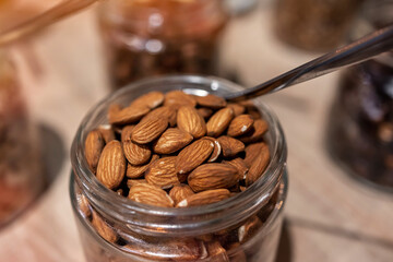 Close-up of almonds in a glass jar with a spoon
