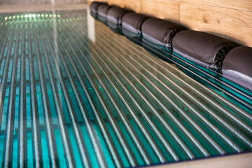 Modern spa pool with metal grating and water reflections