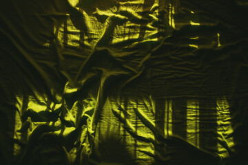 Wrinkled bed sheets as background, top view of crumpled green bed linen texture