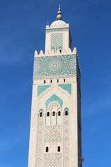 Fototapeta premium Hassan II Mosque with Majestic Minaret Against Clear Blue Sky
