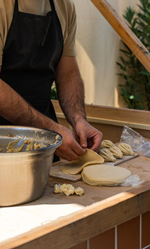 Close-up of a man cooking traditional Georgian khinkali at a market stall, Georgia