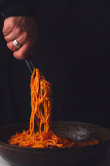 Spaghetti all'assassina is a typical Apulian recipe, Bari. Trendy first course, pasta cooked directly in a pan with tomato sauce, for a charred, crunchy and spicy flavor. Chef's hand serving pasta