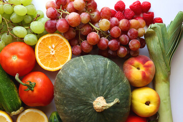 Various seasonal fruits and vegetables on white background. Summer and fall produce. Top view.