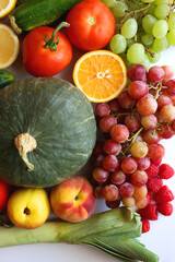 Various seasonal fruits and vegetables on white background. Summer and fall produce. Top view.