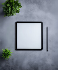 Aerial view of a tidy workspace setup with a tablet, stylus, and laptop, complemented by indoor plants. The modern arrangement on a wooden desk offers a refreshing vibe, merging nature with technology