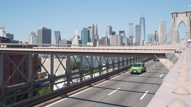 Cars on Brooklyn Bridge. New York City Manhattan downtown skyline, financial district cityscape architecture. World Trade Center, WTC skyscraper. Road traffic to Dumbo, yellow cab and green boro taxi.