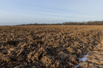 the plowed soil covered with snow and frost on the field