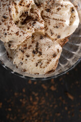 white creamy ice cream with pieces and crumbs of chocolate in a glass bowl