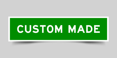 Green color square shape sticker label with word custom made on gray background