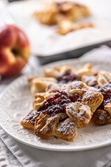 Sweet dessert pastries made of puff pastry with strawberry jam filled with caramelized apple sprinkled with powdered sugar