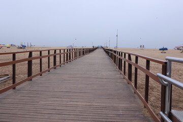 Obraz premium Boardwalk wooden pathway at marina beach in Chennai. a ramp for disabled to reach the beach waters