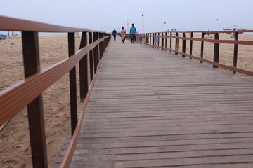 Obraz premium Boardwalk wooden pathway at marina beach in Chennai. a ramp for disabled to reach the beach waters