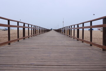 Fototapeta premium Boardwalk wooden pathway at marina beach in Chennai. a ramp for disabled to reach the beach waters