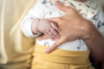 Obraz premium New born baby holding on to mothers hand.
