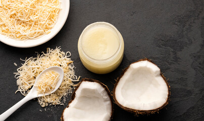 Cocos nucifera - spoon and bowl with oil and grated coconut.