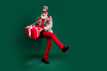 Full body portrait of eccentric grandfather giftbox xmas tree toys blazer red pants empty space...