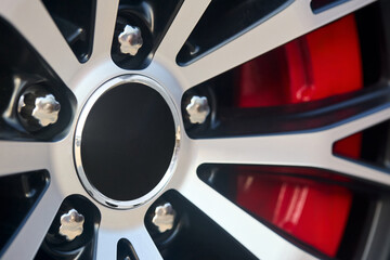 Alloy wheel plug with red brake calipers and rims selective focus closeup car detailing.