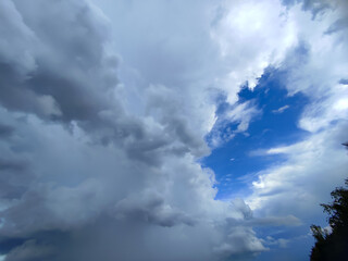 Thick clouds cover the sky, leaving a small blue space that forms a pattern resembling a human face viewed in profile.