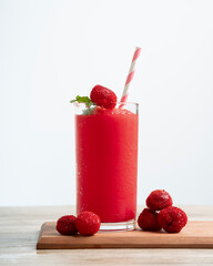 Raspberry smoothie with mint leaves on wooden table with white background
