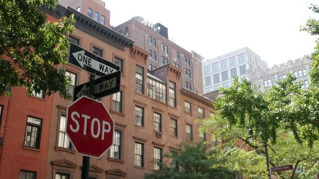 New York City oneway crossroad, Stuyvesant street intersection one way arrow. Manhattan Midtown residential building architecture, United States real estate. Red brick house wall, red stop road sign.