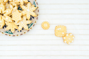 Sugar icing Christmas cookies of different shapes: star, button, snowflake, one with the message 