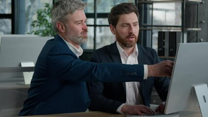 Mature businessman mentoring man discussing project on computer consulting investor client about digital investment in office Caucasian businessmen colleagues working together discuss data management