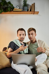 Two partners share a cozy moment while exploring something together online.