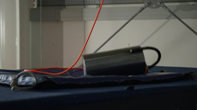 A heavy mass falls from above in slow motion and crushes a mattress, laboratory experience