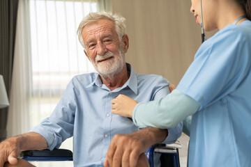 Nurse caregiver using stethoscope checking on heartbeat examining of senior man sitting on...